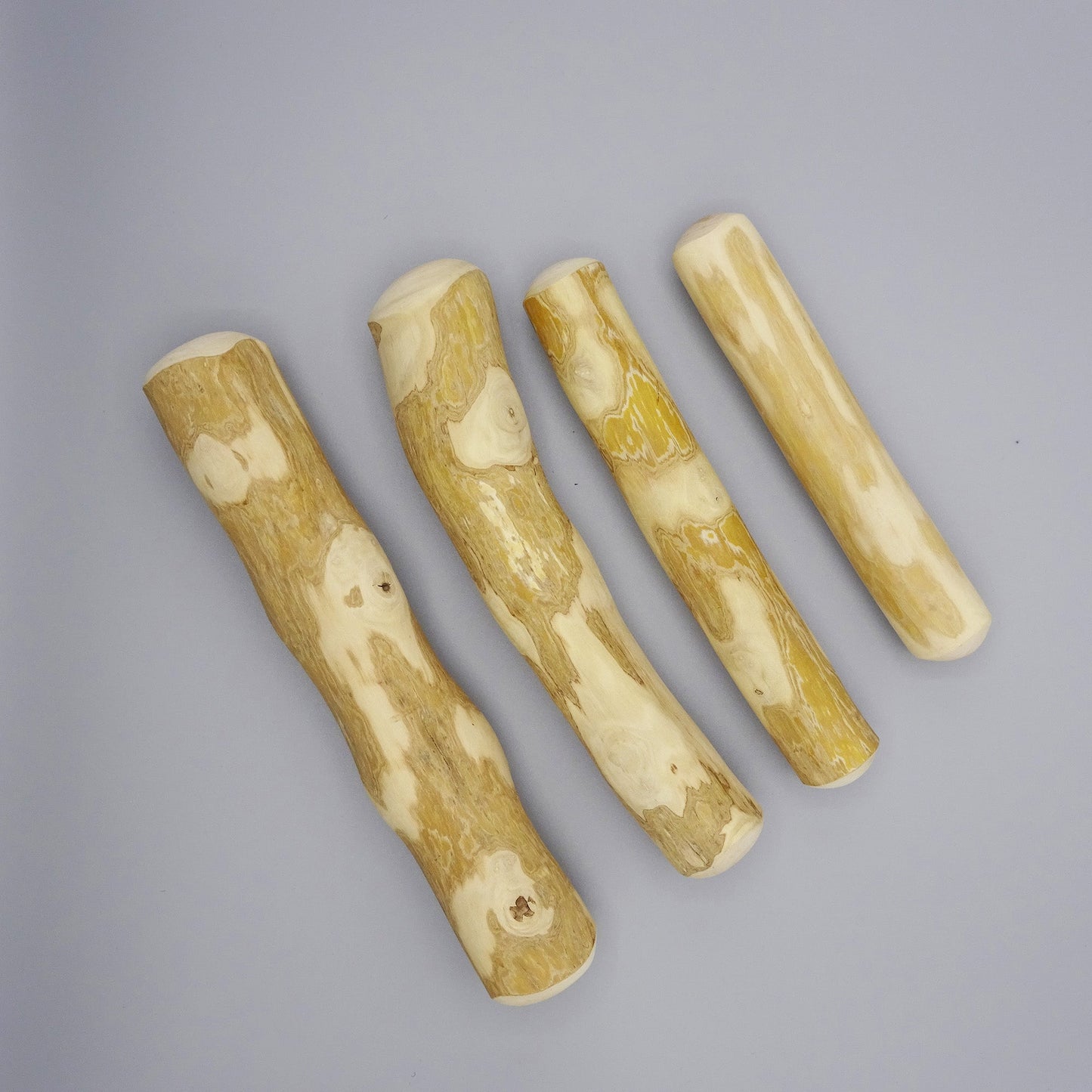 Four coffee wood sticks with natural grain on a gray background 