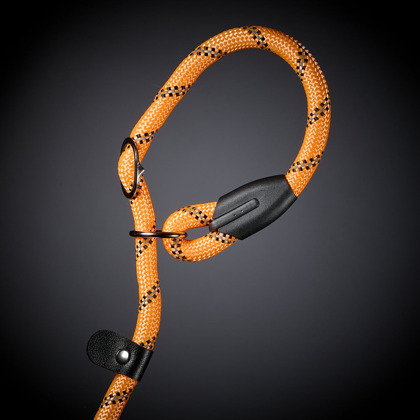 Orange climbing rope with black accents on a dark background